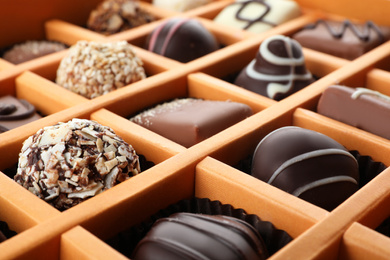 Box with different chocolate candies as background, closeup