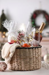 Wicker basket with Christmas gift set on white table