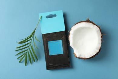 Scented sachet, piece of coconut and leaf on blue background, flat lay