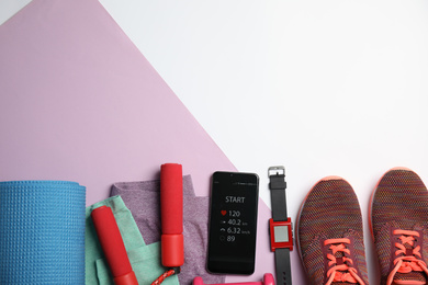 Flat lay composition with fitness equipment and smartphone on color background, space for text