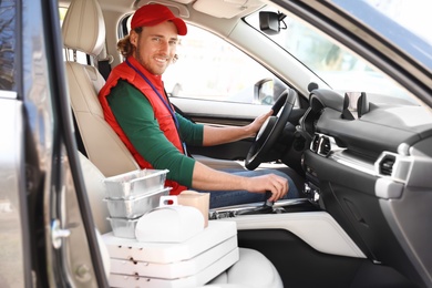 Male courier with orders in car. Food delivery service