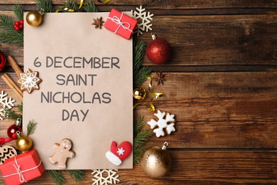 Sheet of paper with words 6 December Saint Nicholas Day and festive decor on wooden table, flat lay. Space for text