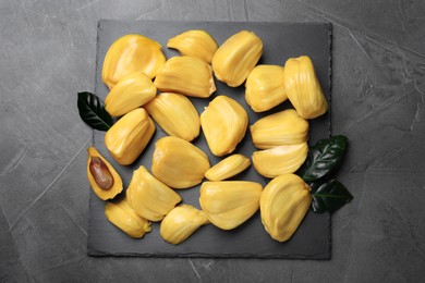 Delicious exotic jackfruit bulbs on grey table, top view