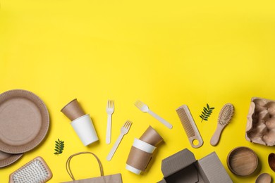 Different eco items on yellow background, flat lay with space for text. Recycling concept
