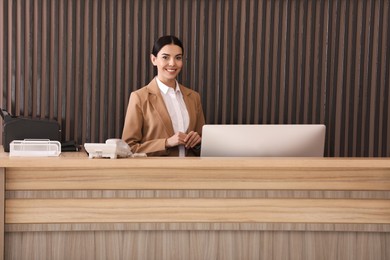 Portrait of receptionist at countertop in office