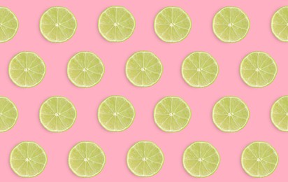 Slices of limes on pink background, flat lay