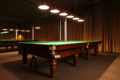 Photo of Stylish billiard table with white balls in pocket indoors