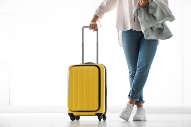 Woman with yellow travel suitcase in airport