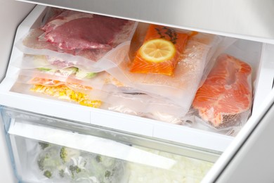Photo of Vacuum bags with different products in fridge. Food storage