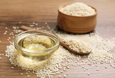 Glass bowl of fresh sesame oil and seeds on wooden table