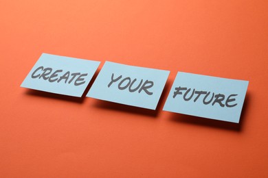 Photo of Motivational phrase Create Your Future made of sticky notes with words on orange background