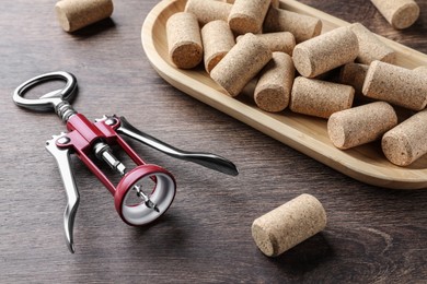 Corkscrew and wine bottle stoppers with plate on wooden table