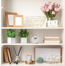 White shelving unit with plants and different decorative stuff