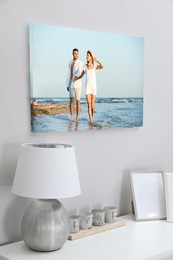 Canvas with printed photo of young couple on white wall in room