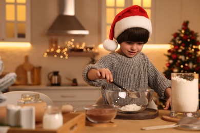 Cute little boy making Christmas cookies in kitchen