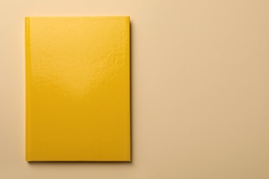 New yellow planner on beige background, top view. Space for text