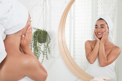 Beautiful young woman with perfect skin near mirror in bathroom. Facial wash