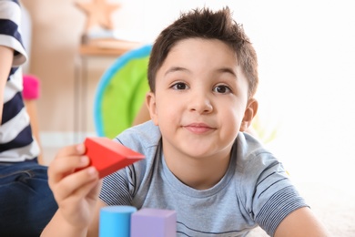 Cute little child playing with building blocks, closeup