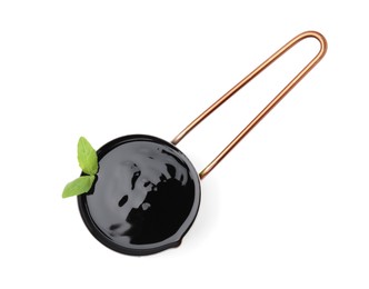 Photo of Balsamic glaze with basil leaves in metal small saucepan on white background, top view
