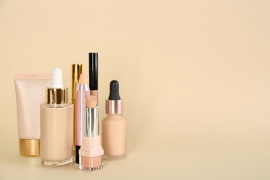 Foundation makeup products on beige background, space for text. Decorative cosmetics