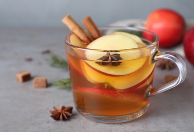 Aromatic hot mulled cider on grey table