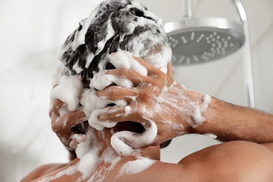 Man washing hair in shower at home, closeup