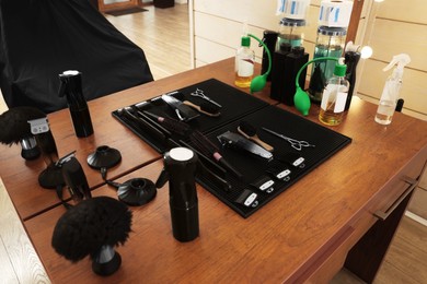 Set of hairdressing tools on wooden table in salon