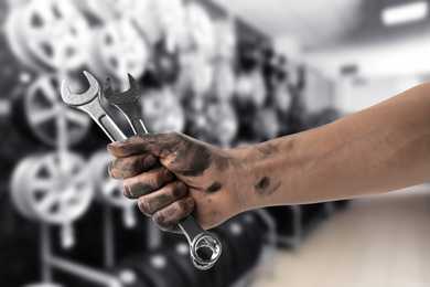 Image of Mechanic with wrenches at tire shop, closeup