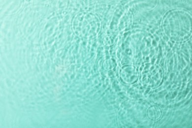 Clear water with rippled surface on turquoise background, top view