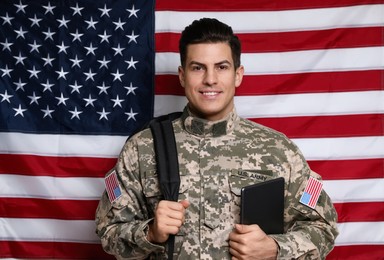 Cadet with backpack and tablet against American flag. Military education