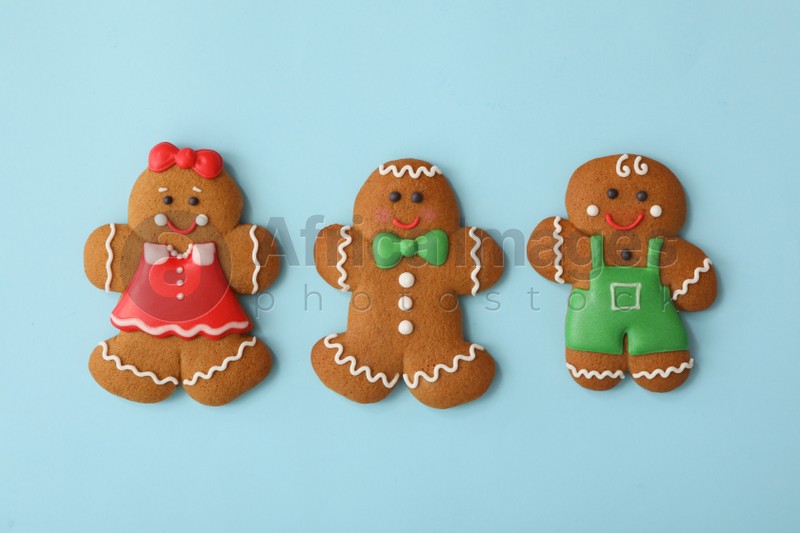 Christmas human shaped gingerbread cookies on light blue background, flat lay