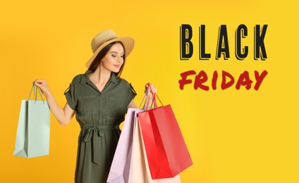 Black Friday Sale. Beautiful young woman with shopping bags on yellow background