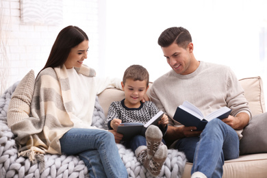 Happy family with little son reading books at home. Winter vacation