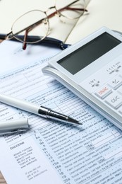 Calculator, glasses, documents and stationery on table, closeup. Tax accounting