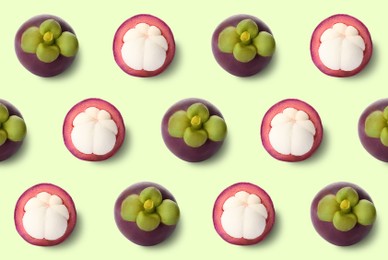 Delicious mangosteens on light green background, flat lay