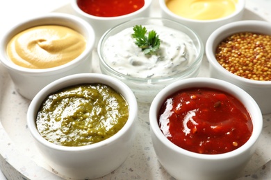 Set of different delicious sauces on tray, closeup