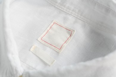 Blank clothing labels on white shirt, closeup
