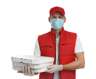 Courier in protective mask and gloves holding pizza boxes on white background. Food delivery service during coronavirus quarantine