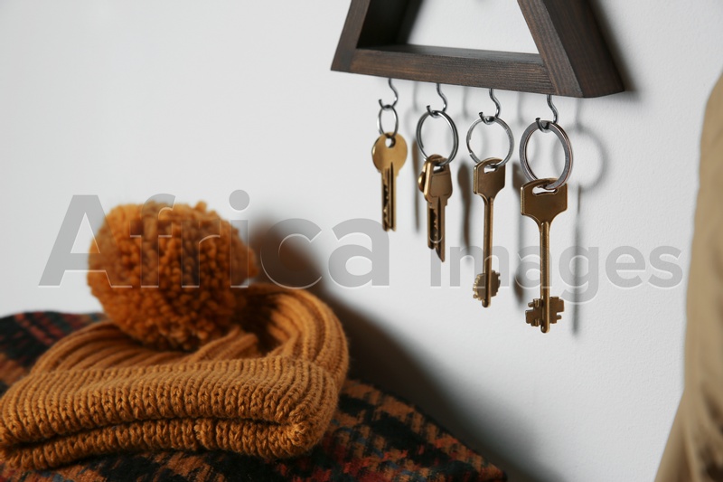 Wooden key holder on light wall indoors