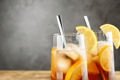Glasses of refreshing iced tea against grey background, closeup. Space for text