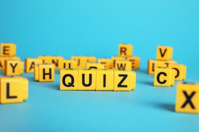 Yellow cubes with word Quiz on light blue background. Space for text