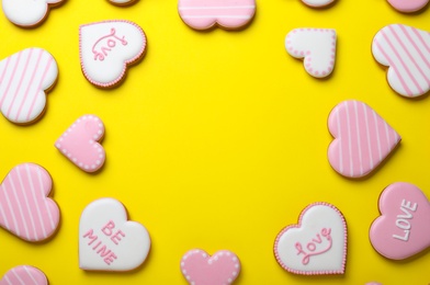 Frame made of cookies on yellow background, flat lay with space for text. Valentine's day treat