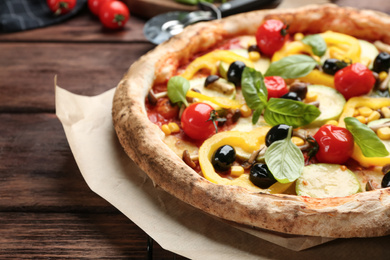 Tasty vegetable pizza on wooden table, closeup