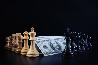 Photo of Different chess pieces and money against dark background. Business competition concept