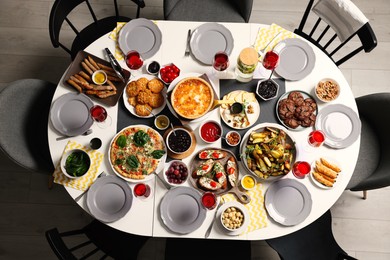 Brunch table setting with different delicious food and chairs indoors, top view