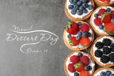 National Dessert Day, October 14. Tasty tartlets with different fresh berries on grey table, flat lay