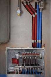 Underfloor heating system. Manifold with pipes in building