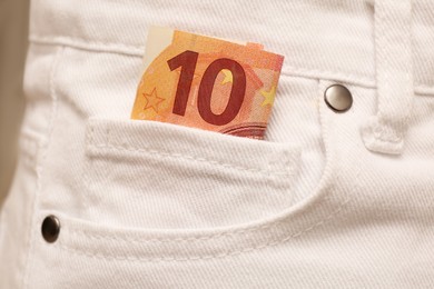 Euro banknote in pocket of white jeans, closeup. Spending money