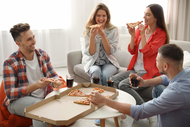 Group of friends eating tasty pizza at home