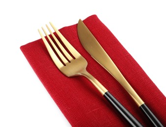 Photo of Red napkin with golden fork and knife on white background, closeup